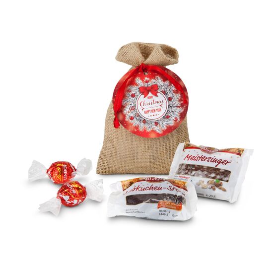 1 Oblaten-Lebkuchen (28 g, glasiert), 1 Lebkuchen-Stern (25 g, schokoliert) & 2 Lindorkugeln (je 12,5 g) verpackt im Jutesäckchen.